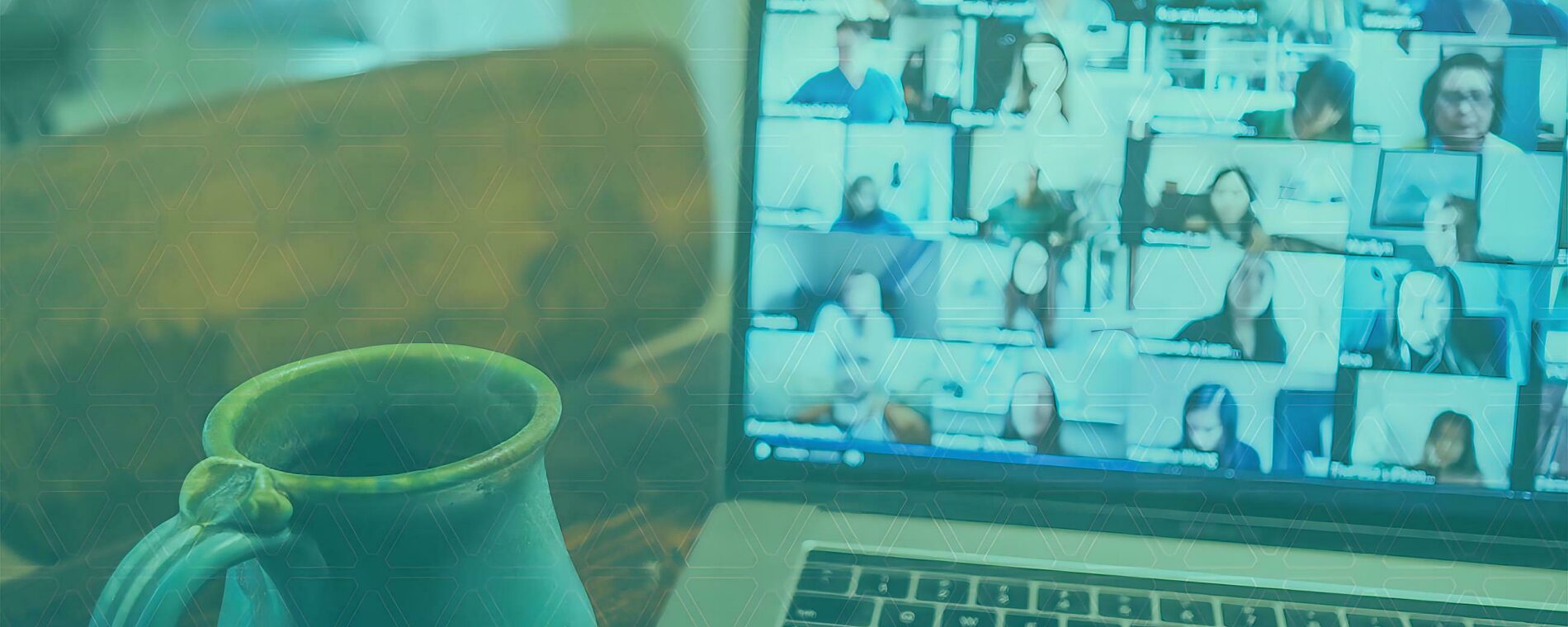 A coffee mug sitting in front of an open laptop.