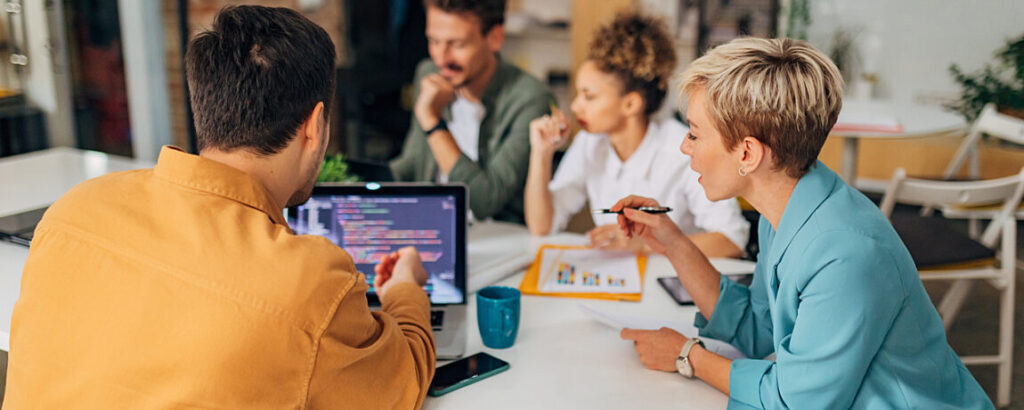 A group of people around a table, in a meeting.