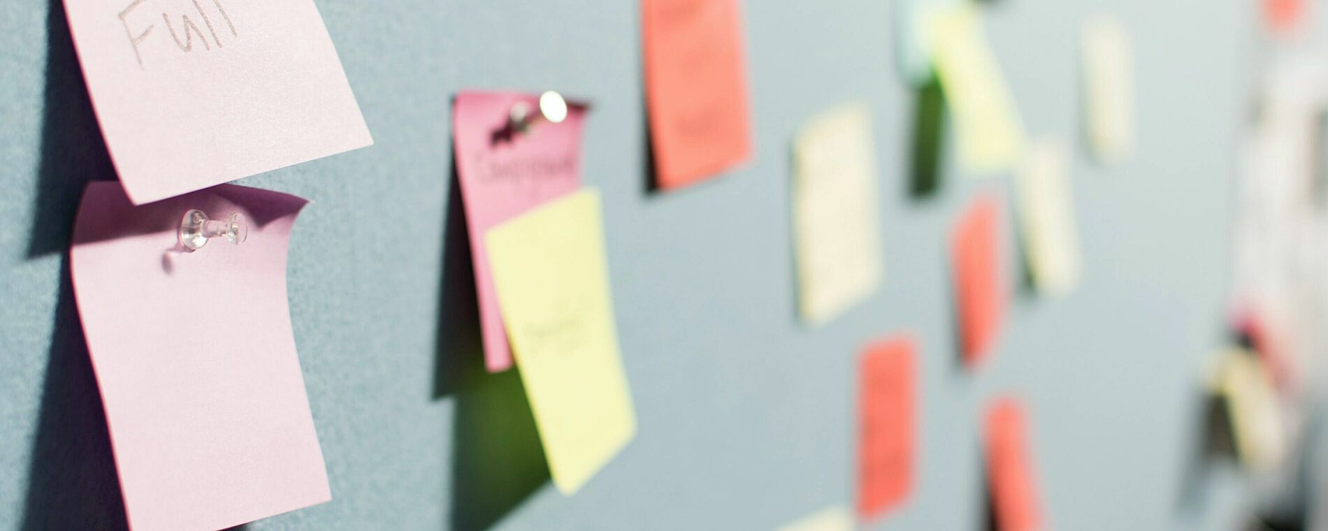 sticky notes stuck to a cubicle