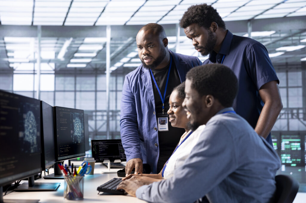 IT Members talking around a laptop.